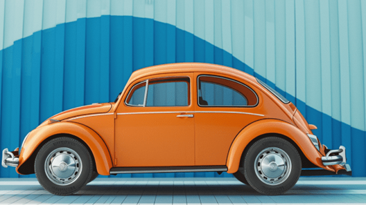 Orange Volkswagen Beetle with a blue downard trending graph on the wall behind it