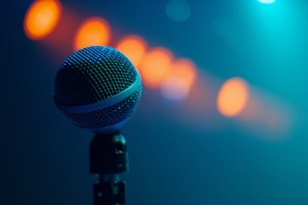 A microphone with orange spotlights and a blue background.