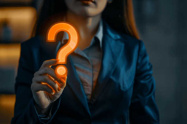 Businesswoman holding neon orange question mark
