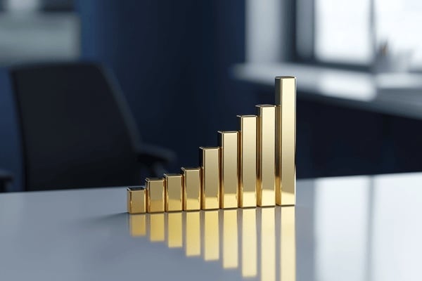 An increasing bar graph of gold blocks sits on an office desk