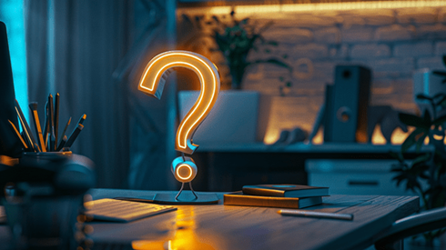 Glowing question mark on an office desktop