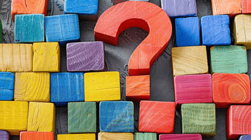 A wooden question mark surrounded by colored wooden blocks