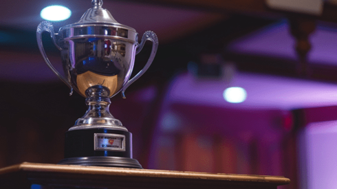 A silver trophy sitting on top of a speaker poduium