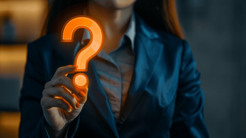 Businesswoman holding neon orange question mark