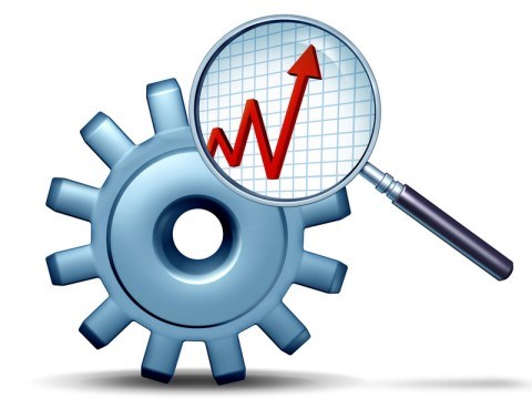 A magnifying glass analyzes two cogs of a gear and reveals a red graph line with high and low markers ending in upward arrow