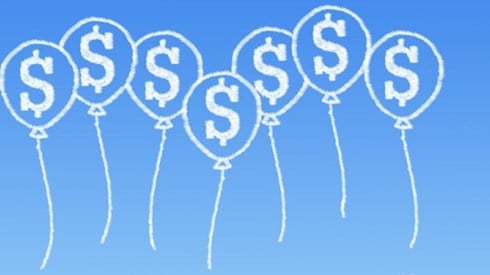 Clouds in the sky in the shape of baloons embossed with dollar signs