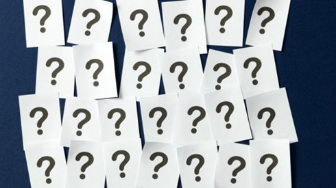 Four rows of sheets of paper with a question mark printed on each