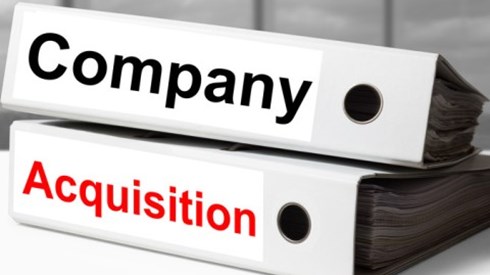 Stack of two white binders with the words company and acquisition in black and red text across the spines