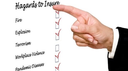 Businessman checking off coverages on an insurance hazards list with his finger