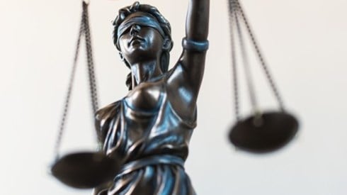 Partial view of the Roman god Lady Justice blindfolded holding a set of scales in one hand