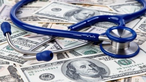 A stethoscope laying on a pile of money