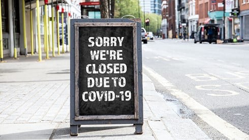 Sorry Closed for COVID-19 sign on standing sign on sidewalk