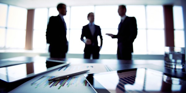 Silhouettes of three businessmen at a planning meeting